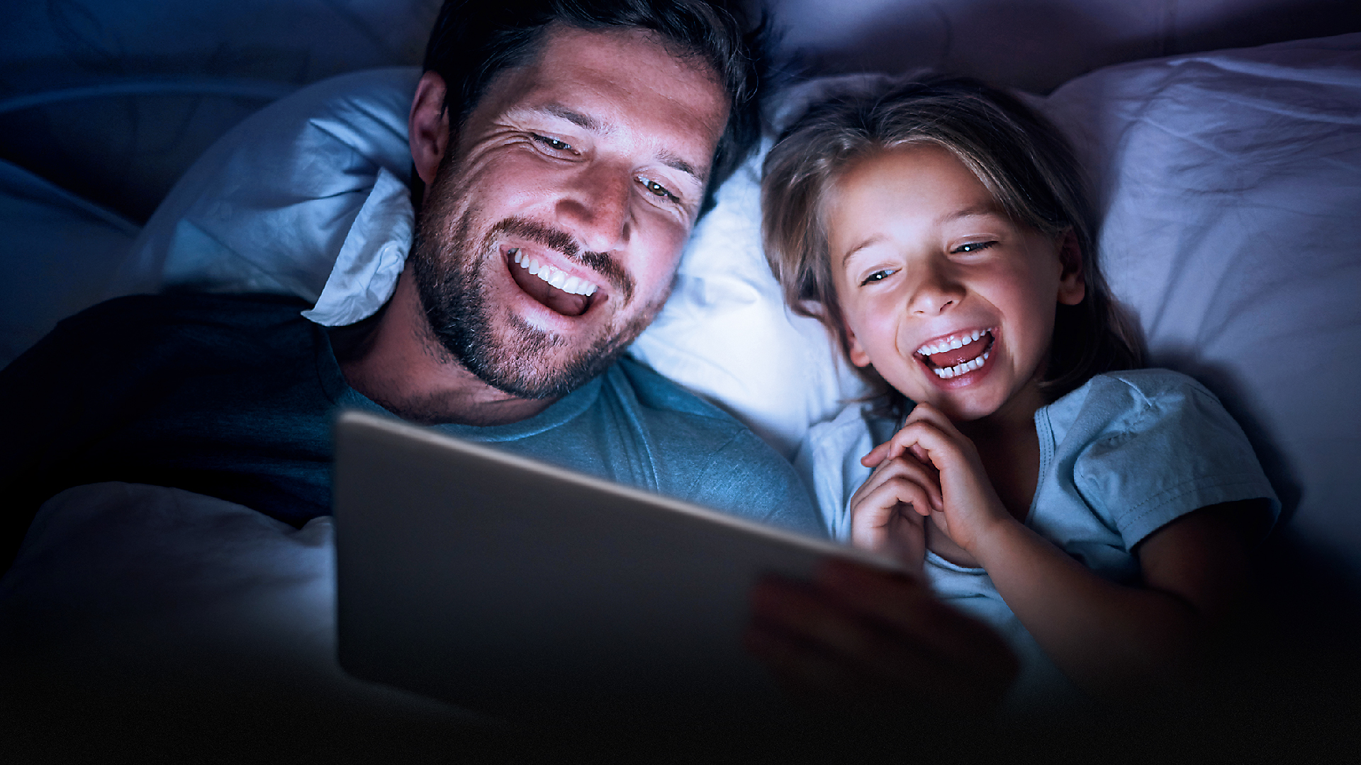 Vater und Kind schauen gemeinsam waipu.tv auf einem Tablet